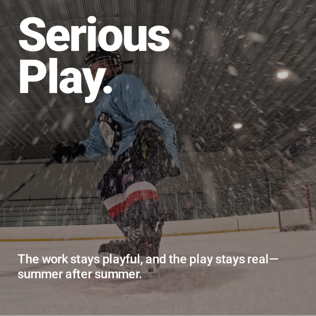 Youth hockey player skating hard through ice spray in an indoor rink.
